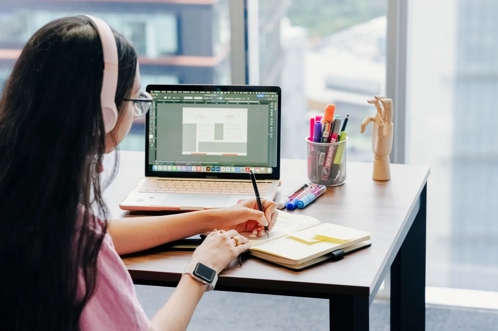 A professional working with a laptop and notebook