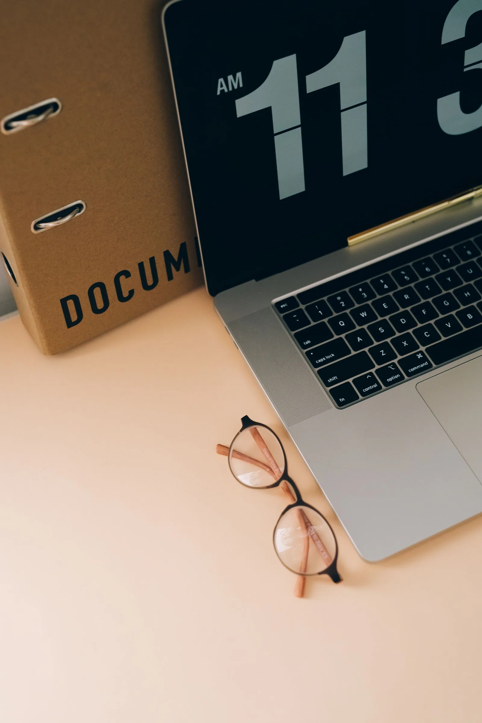 Laptop, eyeglasses and an organised document binder